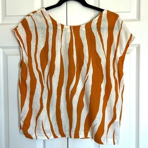 Sleeveless shirt with orange zebra stripes.